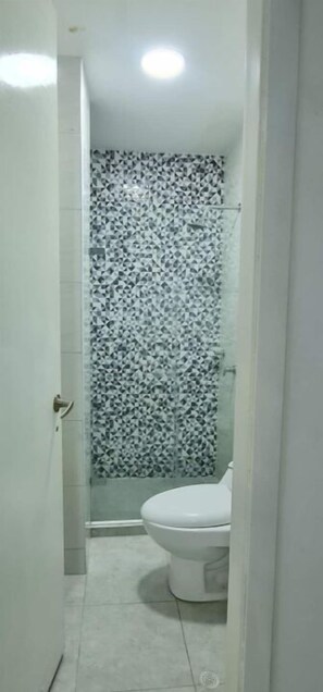 Bañera con ducha, toallas, jabón, shampoo