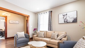A living room with a beige sofa, two armchairs, a coffee table, and a painting of a horse. - Valhalla View Home-Minutes to Golf Course-Perfect for Golfers, Horses, Trailers (Louisville)