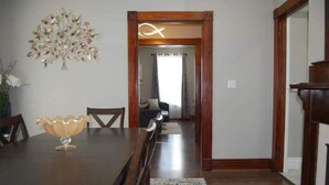 A dining area with a wooden table, chairs, and a decorative bowl. There is a mirror on the wall and a door leading to another room. - Valhalla View Home-Minutes to Golf Course-Perfect for Golfers, Horses, Trailers (Louisville)