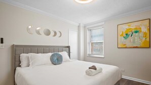 A bedroom with a large bed, a window with blinds, a wall-mounted artwork, and a door. - FIFA 2026 Walk to Stadium | 1BR Unit 3-O ATL (Atlanta)