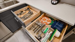 A kitchen with a drawer organizer containing utensils, a cutting board with orange slices, and a coffee maker. - FIFA 2026 Walk to Stadium | 1BR Unit 3-O ATL (Atlanta)