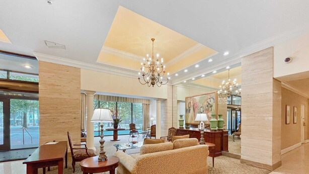 A spacious lobby with a large sofa, a chandelier, and a coffee table. - FIFA 2026 Walk to Stadium | 1BR Unit 3-O ATL (Atlanta)