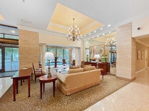 A spacious lobby with a large sofa, a chandelier, and a coffee table. - FIFA 2026 Walk to Stadium | 1BR Unit 3-O ATL (Atlanta)