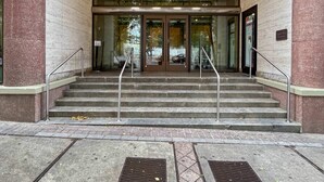 The entrance to Peachtree Towers with a brick facade, double doors, and a set of stairs leading up to the entrance. - FIFA 2026 Walk to Stadium | 1BR Unit 3-O ATL (Atlanta)