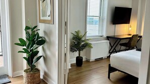 Ein modernes Wohnzimmer mit einer Couch, einem Flachbildfernseher und zwei Zimmerpflanzen.