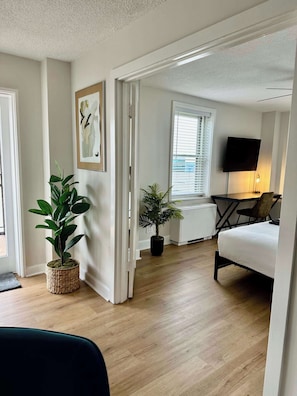 Un salon moderne avec un canapé, un téléviseur à écran plat et deux plantes en pot.