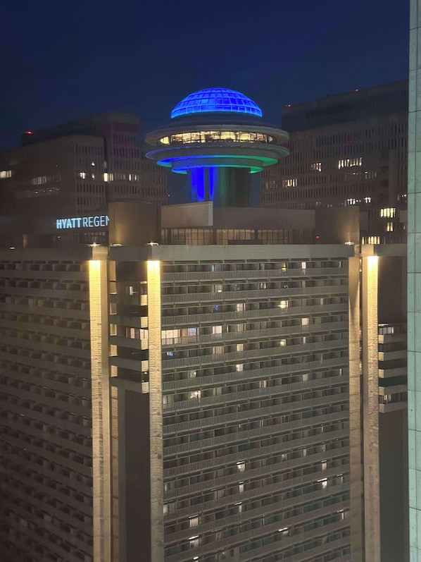 Un immeuble de grande hauteur, surmontĂ© dâun dĂŽme imposant, illuminĂ© de lumiĂšre bleue.