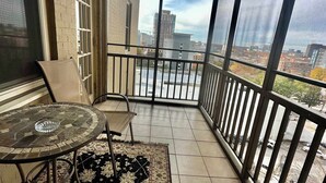 A balcony with a tiled floor, a round table with a glass bowl, a chair, and a patterned rug. - FIFA 2026 Walk to Stadium | 1BR Unit 7-O ATL (Atlanta)
