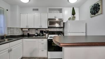 Fridge, microwave, coffee/tea maker, cookware/dishes/utensils