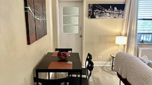 Un espacio habitable compacto con comedor, cama y vistas a la ciudad.