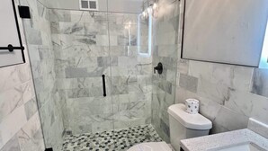 Un baño con ducha, inodoro y lavabo.