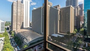A view of a cityscape with tall buildings, including a large white building with a curved roof and a modern glass building.