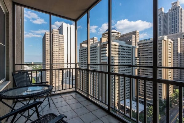 Enjoy unobstructed city views from this spacious balcony with a glass partition and metal railing.