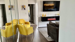 A modern living room with a flat-screen TV, a fireplace, and a sofa. - FIFA 2026 Walk to Stadium | 1BR Unit 24B ATL (Atlanta)
