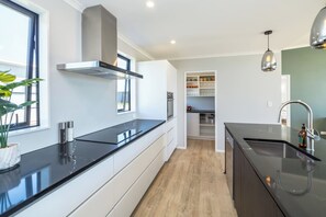 A modern kitchen with black countertops, stainless steel appliances, and a built-in oven.