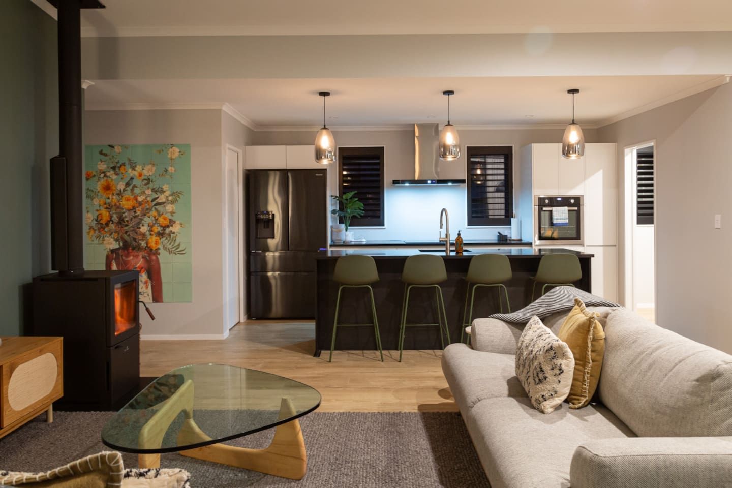 A modern living room with a glass coffee table, a sofa with cushions, and a fireplace.