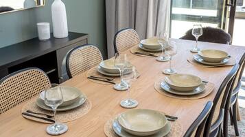 A dining table set for six with plates, glasses, and cutlery.