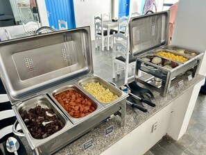 A buffet with various food items including sausages, rice, and other dishes. - KYROS POUSADA (Maceió)