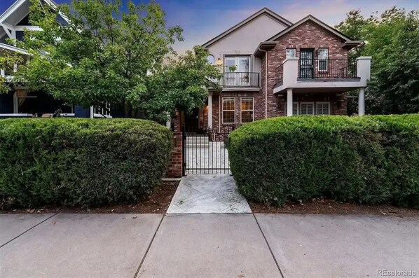 A two-story house with a brick facade, a balcony, and a gated entrance. - House in front of Washington Park

 (Denver)