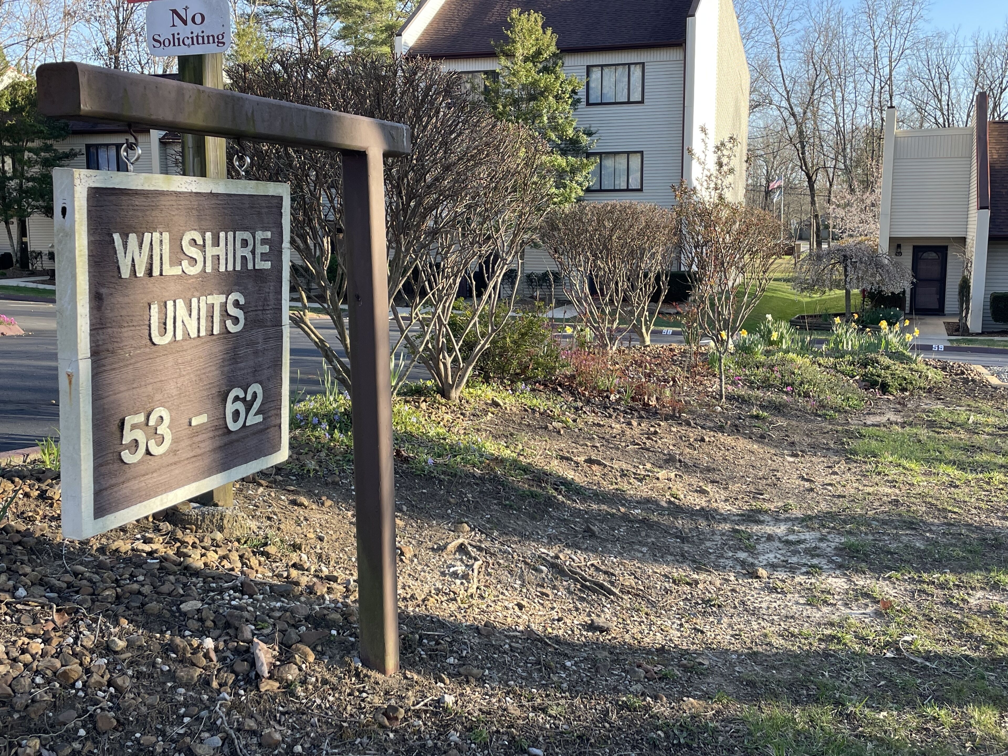 Señal para Wilshire Units, números 53 al 62, con un cartel de 'No se permite la venta puerta a puerta' encima.