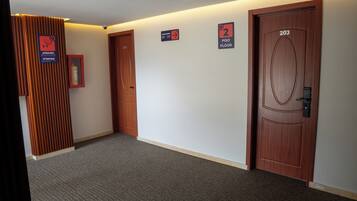 Un pasillo con dos puertas, una con el número '203' y otra con un cartel de '2' que indica el segundo piso.