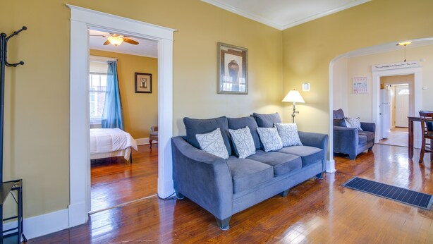 A living room with a gray sofa, a wooden floor, and a ceiling fan. - Walk to Parks & Dining! Memphis Home w/ Yard (Memphis)