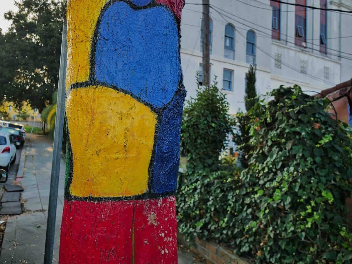 Een kleurrijk beschilderde paal met een ontwerp in blauw, geel en rood.