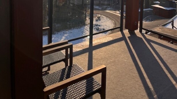 En balkong med utsikt över ett snötäckt landskap och en klar himmel.