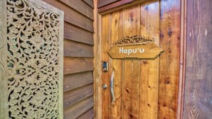 A wooden door with a carved panel and a sign that reads "Hapu'u".