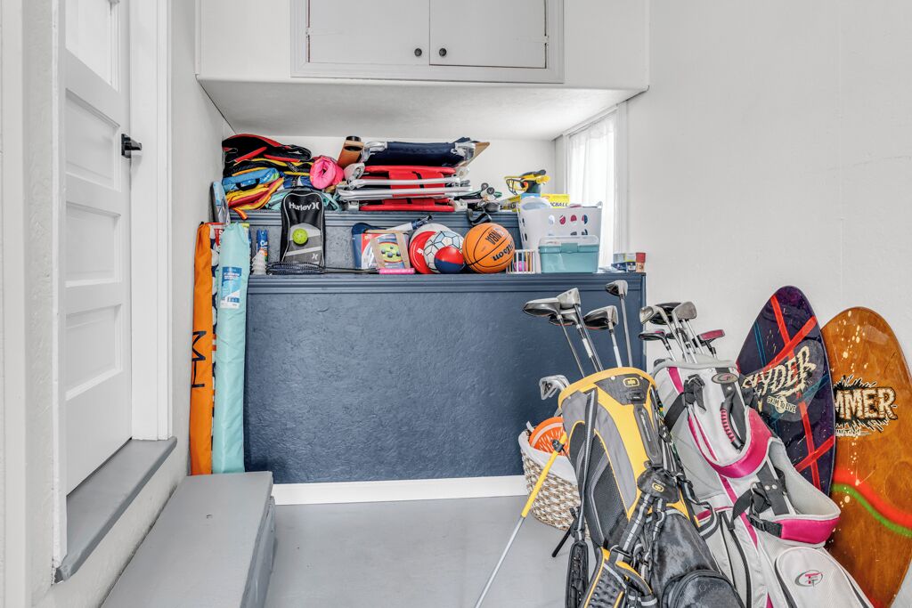 Espacio de almacenamiento compacto con diverso equipo deportivo, como patinetas y una bicicleta.