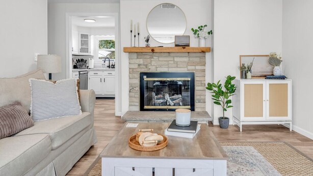 A living room with a fireplace, a sofa, a coffee table, and a cabinet. - Great Hammcock Getaway, cozy home, hot tub, fire pit, beaches nearby. (Old Saybrook)