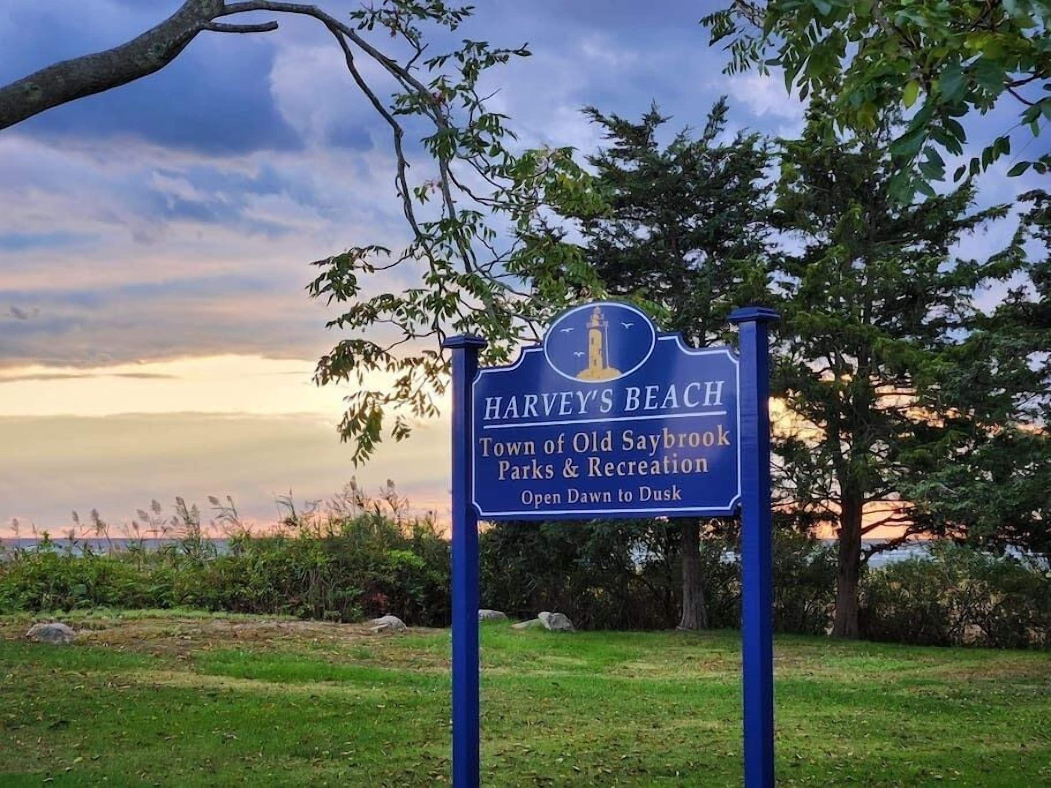 Señal para Harvey's Beach, Parques y Recreación del Pueblo de Old Saybrook, indicando horario de apertura de amanecer a anochecer.