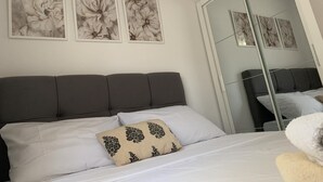 A bedroom with a bed, a mirror, and three floral wall art pieces. - Apartments J&M 2 - One Bedroom Apartment with Terrace (Rogoznica)