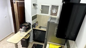 A compact kitchen with a refrigerator, sink, and a small countertop. - 819 · 2BR Townhouse | Garden | Sleeps 5 (Sheikh Zayed City)