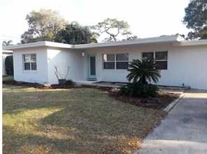 A single-story house with a front porch, a small front yard, and a driveway.