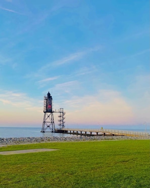 A lighthouse on a pier with a clear sky.