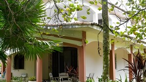 A house with a covered porch, outdoor seating, and potted plants.