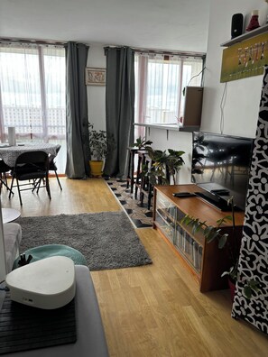 Relax in this stylish living room with a sofa, dining table, and flat-screen TV.