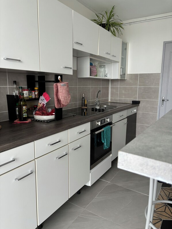 Enjoy cooking in this well-equipped kitchen with an oven, stainless steel sink, and ample countertop space.