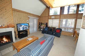 A cozy living room with a fireplace, a television, a sofa, and a coffee table.