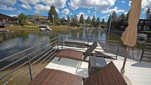 A lakeside deck with metal railings, a table, and chairs. - Waterfront Home, Private Hot Tub/Boat Dock - Views! (South Lake Tahoe)