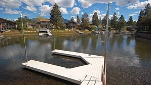 A calm lake with a dock and boats, surrounded by houses and trees under a partly cloudy sky. - Waterfront Home, Private Hot Tub/Boat Dock - Views! (South Lake Tahoe)