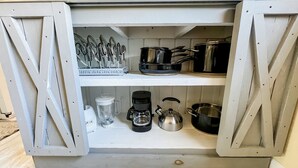 A kitchen cabinet with open doors revealing utensils, cookware, and appliances. - Cute & cozy family-friendly Royal Oak ranch close to downtown and highways! (Royal Oak)