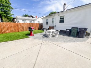 A backyard with a patio, a barbecue grill, and trash bins. - Cute & cozy family-friendly Royal Oak ranch close to downtown and highways! (Royal Oak)