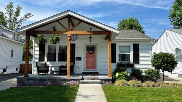 A single-story house with a covered porch, a front door, and a small garden area. - Cute & cozy family-friendly Royal Oak ranch close to downtown and highways! (Royal Oak)