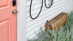 A house with a pink door, a black charging cable, and a wooden planter. - Cute & cozy family-friendly Royal Oak ranch close to downtown and highways! (Royal Oak)