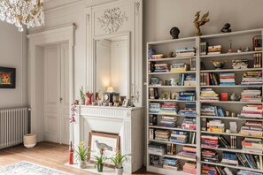 A room with a fireplace, bookshelves, and decorative items.