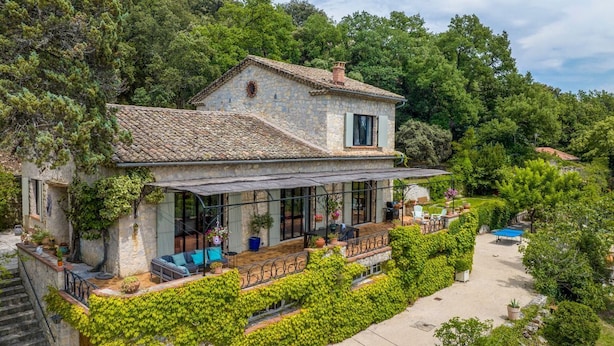 A stone house with a covered patio, surrounded by lush greenery and trees. - Mas Mayeaux - Six Bedroom Villa, Sleeps 12 (Vaison-la-Romaine)