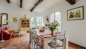 Un comedor con una mesa y sillas de madera, un sofá rojo y una estantería.