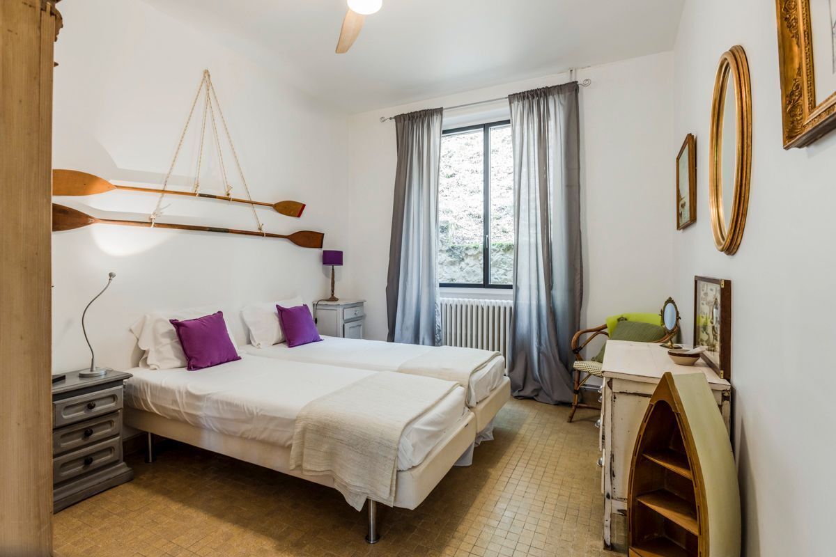 Un dormitorio con dos camas, un escritorio y una ventana con cortinas.